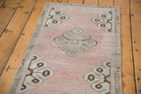 Angled view of the blanched pale rose Oushak runner, with curvilinear bronze and silver motifs.