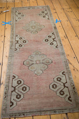 Blanched pale rose field with simplified curvilinear motif in silver and bronze tones.