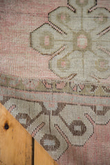 Blanched pale rose field and bronze curvilinear motif on a vintage Oushak runner.