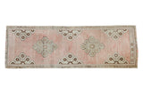 Blanched vintage Oushak runner with a pale rose field and silver-bronze curvilinear medallions.