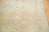 Vintage Oushak rug surface showing subtle curvilinear patterns on creamy beige pile.
