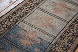 Vintage Oushak runner's geometric pattern blocks in powder blue and soft peach tones.