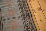 Geometric black and beige border, with peach motifs on powder blue vintage Oushak runner.