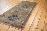 Distressed Oushak runner with tone-on-tone dusty grey field and navy, terra cotta motifs.