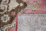 Distressed Oushak rug corner, deep rose pile, tangerine edge, hand knotted ivory foundation.
