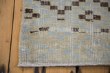 Distressed Oushak runner edge showcasing geometric checker pattern in beige and silver tones.
