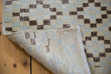 Distressed Oushak runner corner revealing ivory, silver, charcoal geometric pattern and woven back.