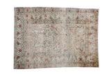 Distressed Kaisery rug with ornate scrolling floral vines in etched muted red and beige.