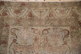 Etched beige and faded rose floral motifs with scrolling vines on a distressed Kaisery rug.