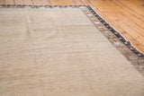 Distressed Oushak carpet close-up, natural undyed wool abrash and textured brown border motifs.