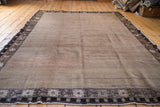 Vintage Oushak corner with natural undyed wool field and dark border featuring soft rose motifs.