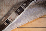Distressed Oushak rug back, with natural wool foundation and dark geometric border.