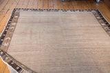 Natural undyed wool with strong abrash and dark patterned borders on this distressed Oushak.