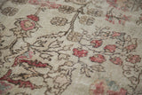 Distressed ivory pile with rosy cinnabar blossoming vines and tendrils.