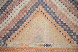 Geometric zig-zag bands, scattered diamond motifs, and orange border on a vintage Jajim rug.