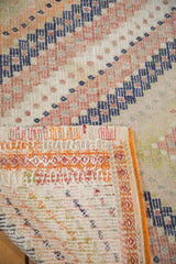 Folded corner of a vintage Jijim rug, showing hand-woven geometric patterns and intricate orange edge.