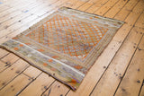 Textured orange diamond pattern and border details on the distressed Jijim rug.
