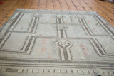 Distressed Jijim rug featuring silvery sea foam green, linear patterns, and pink diamond motifs.