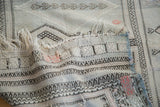 Distressed Jijim rug close-up, showing interwoven linear patterns and frayed fringe.