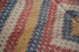 Vintage Jijim carpet detail: hand-woven staggered blocks in denim blue, red, ivory, yellow.