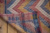 Vintage Jajim hand-woven carpet corner, revealing intricate texture and colorful geometric patterns.