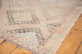 Hand-woven vintage Jijim carpet corner, showcasing geometric patterns, texture, and fringe.
