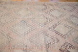 Geometric medallions and woven texture of a vintage Jijim carpet in sea foam, grapefruit, aubergine.