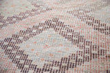Intricate geometric medallions with sea foam, grapefruit, and aubergine woven texture.