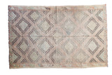 Vintage hand-woven Jijim rug featuring geometric medallions in sea foam, grapefruit, and aubergine.
