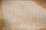 Hand woven Jajim rug's lattice diamond pattern in faded cinnabar, beige, and soft pastel hues.