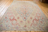 Vintage hand-woven Jijim rug corner showcasing lattice diamond design in muted reds, beiges, and blues.