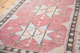 Distressed Jijim runner's faded cranberry and cream geometric star pattern with its unique hand-woven texture.