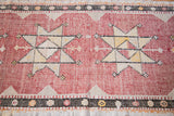 Distressed hand-woven Jijim runner close-up showing star motif, cranberry and cream tones.