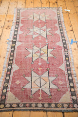 Geometric star motif and textured faded cranberry weave on a vintage Jijim runner.