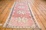 Distressed Jijim runner with faded cranberry hues and hand woven star design.