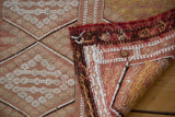 Textured hand-woven vintage Jijim runner with geometric diamond pattern and rich folded edge.