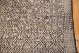Angled detail of the distressed Jajim geometric pattern in charcoal, ivory, and faded brown.