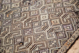 Tightly woven geometric pattern and distressed texture of a vintage Jijim rug detail.