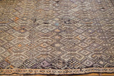 Distressed Jijim rug featuring intricate geometric motifs with faded orange and lavender tones.