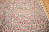 Tightly woven geometric Jajim pattern, with pale faded red diamonds and soft charcoal.