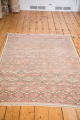 Lower edge and intricate geometric pattern of the faded vintage Jajim rug.