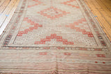 Vintage Jijim flatweave rug with repeating geometric diamond guls in faded cinnabar red and neutral tones.