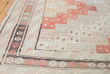 Geometric border of a hand woven vintage Jijim rug in ivory, platinum, cinnabar tones.