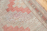 Geometric diamond guls and striped border detail on a vintage Jijim carpet in cinnabar, ivory, and silver.