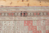 Close-up of vintage Jijim rug's geometric diamond guls in ivory, silver, and cinnabar.
