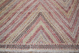 Vintage Jijim hand-woven rug with repeating concentric diamond pattern in sweet, varied colors.