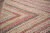 Repeating concentric diamond design in red, brown, and pale yellow on a vintage Jijim rug.