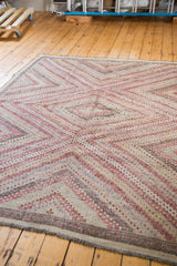 Vintage Jijim rug corner showing muted concentric diamond motifs and fringed edge.