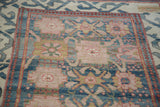 Close-up of vintage Indian rug's arts & crafts palmette motifs and aqua blue border.
