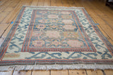 Angled vintage Arts & Crafts rug with sky blue palmettes, peach, green, and detailed red, aqua borders.
